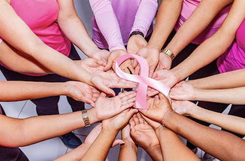 Hands holding a pink ribbon